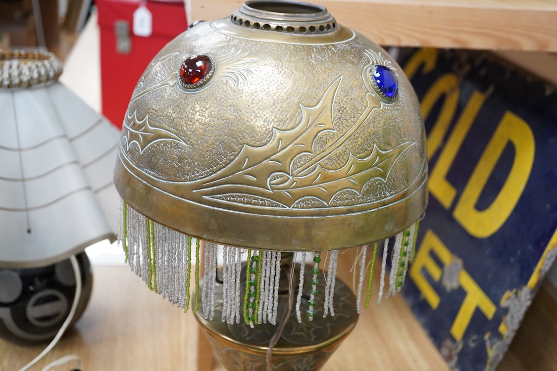 After Georges Leleu, an Art Nouveau brass oil lamp converted to electricity, with glass cabochon roundels and beaded fringing, 50cm high
